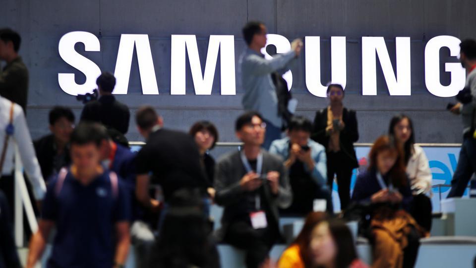 People sit in front of a Samsung logo at the IFA consumer tech fair in Berlin, Germany, September 6, 2019. REUTERS/Hannibal Hanschke